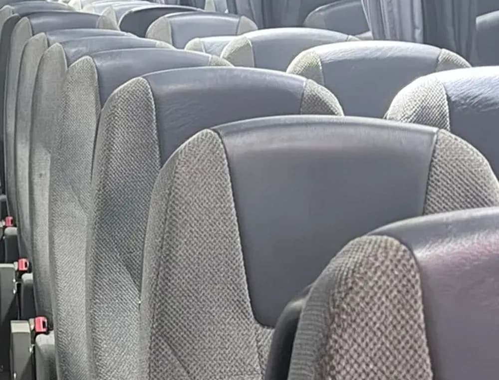 Primer plano de las butacas reclinables grises de cabecero azul del autobús VDL de 55 plazas de Winking Bus