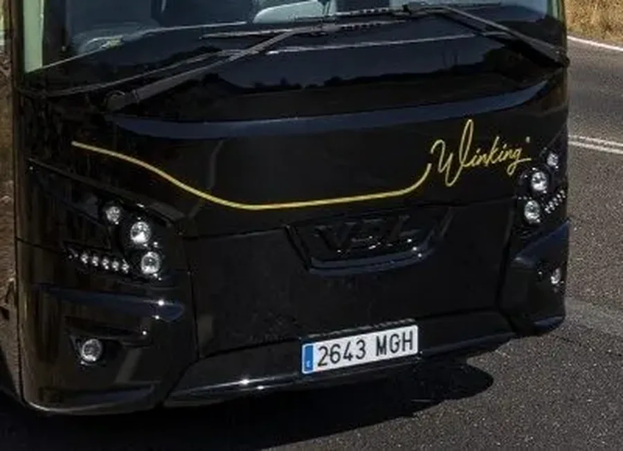 Frontal del autobús VDL de 55 plazas de Winking Bus, con los faros LED y el rótulo dorado Winking sobre la carrocería negra