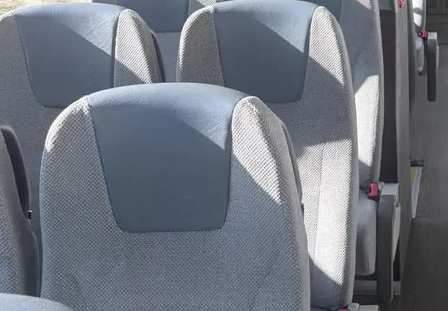 Primer plano de las butacas grises de cabecero azul del autobús VDL de 70 plazas de Winking Bus