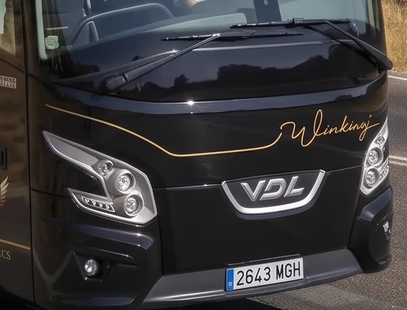 Frontal del autobús VDL de 70 plazas de Winking Bus, con el faro LED, el logotipo VDL y el rótulo dorado Winking sobre la carrocería negra