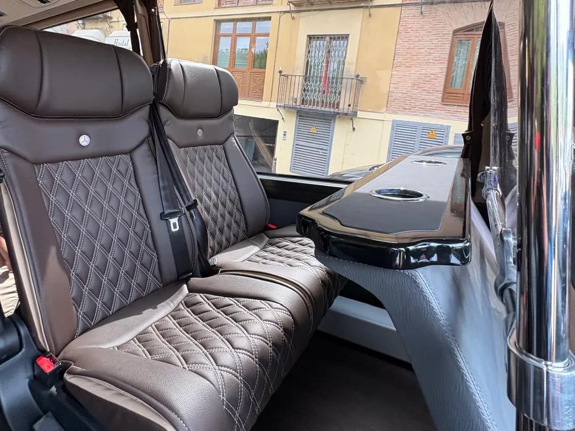 Pareja de butacas de piel marrón con pespunte en rombo y mesa abatible del microbús Mercedes-Benz Sprinter de 19 plazas de Winking Bus